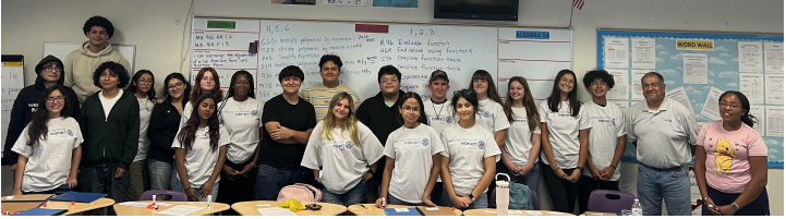 Students in black or white shirts stand together against a wall
